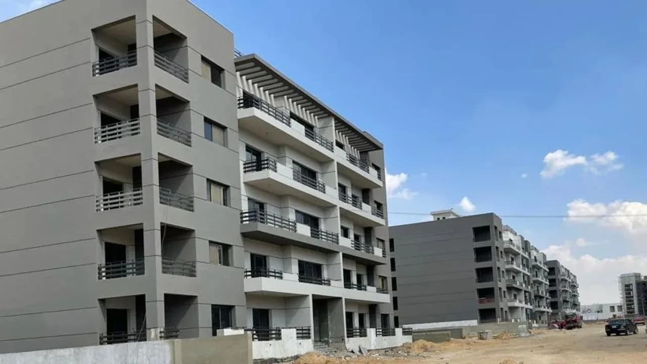 Modern apartment buildings under construction on a clear day.